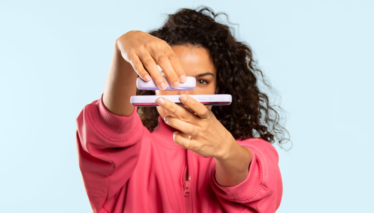 Persoon plaatst draadloze MagSafe powerbank op iPhone.