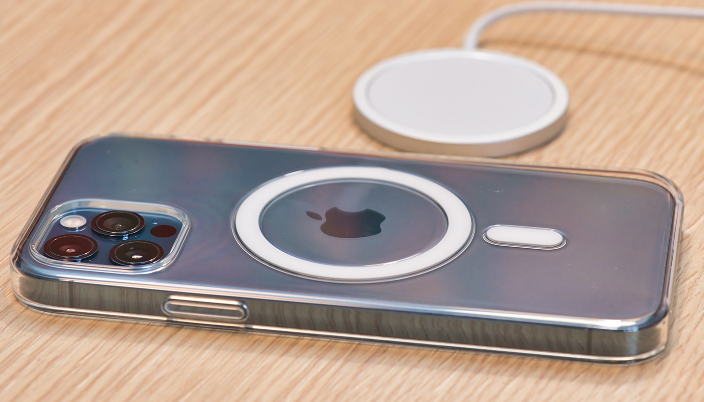 Een iPhone 12 Pro met MagSafe hoesje en een MagSafe oplader liggen op een houten tafel.