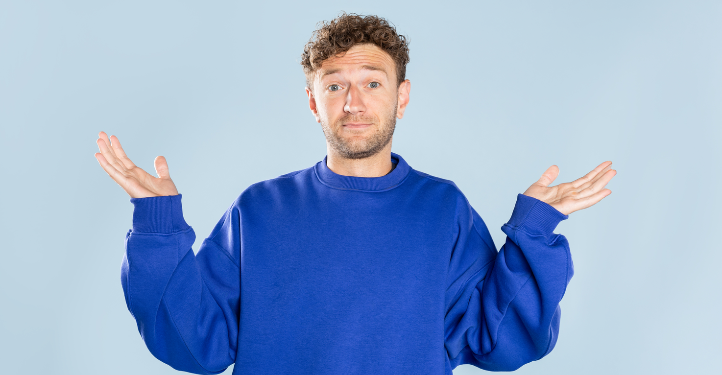 Een man die zijn armen omhoog houdt, alsof hij een vraag stelt of iets niet helemaal begrijpt.