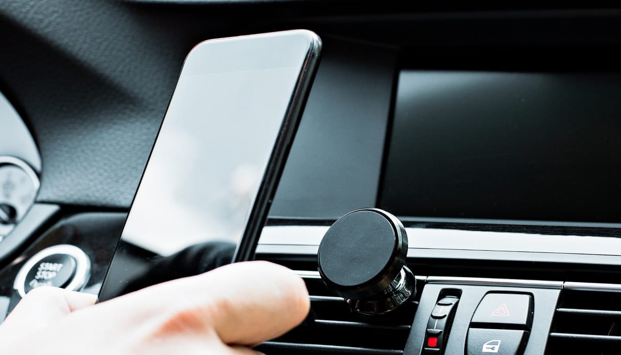 iemand in de auto die telefoon met houders vasthoudt.