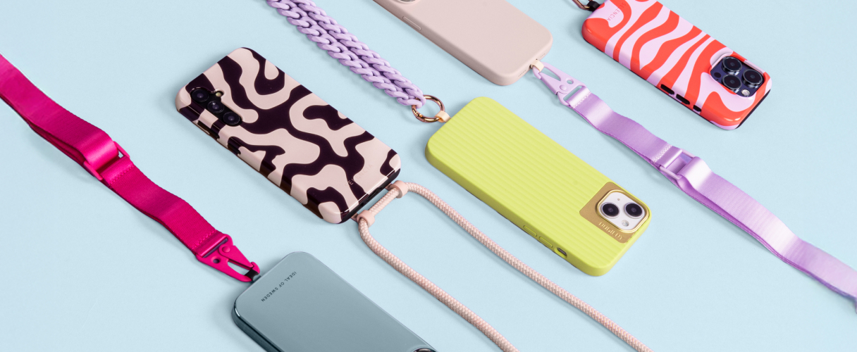 Telefoons met telefoonhoezen en allemaal met telefoonkoord in soorten, maten en kleuren op een lichtblauwe achtergrond.