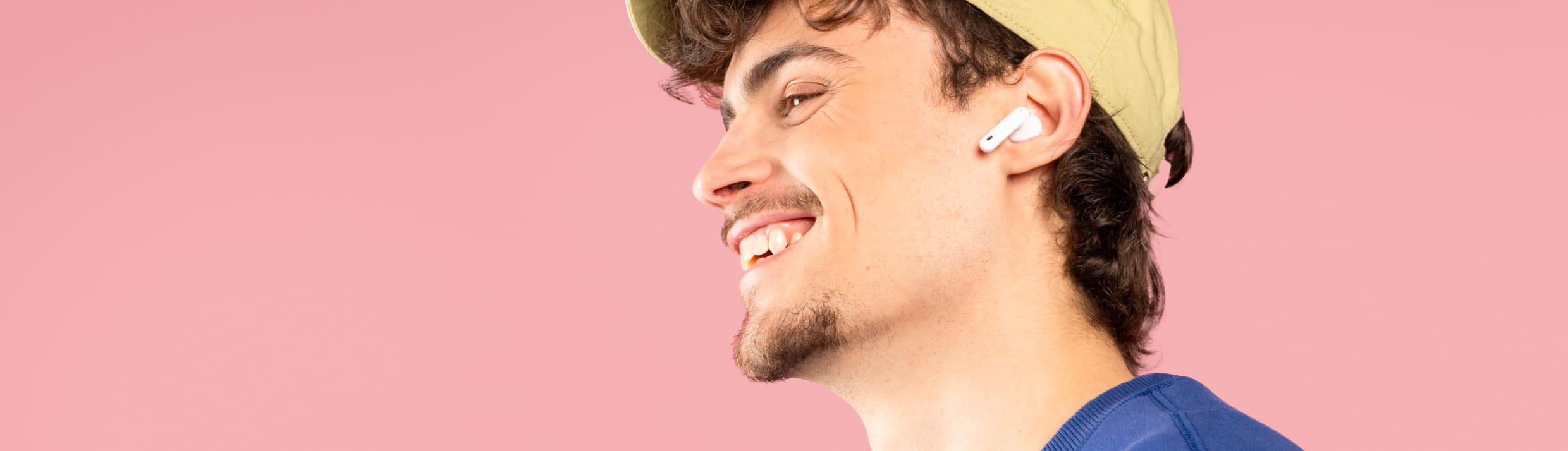 Een man heeft AirPods in zijn oren en luistert muziek.