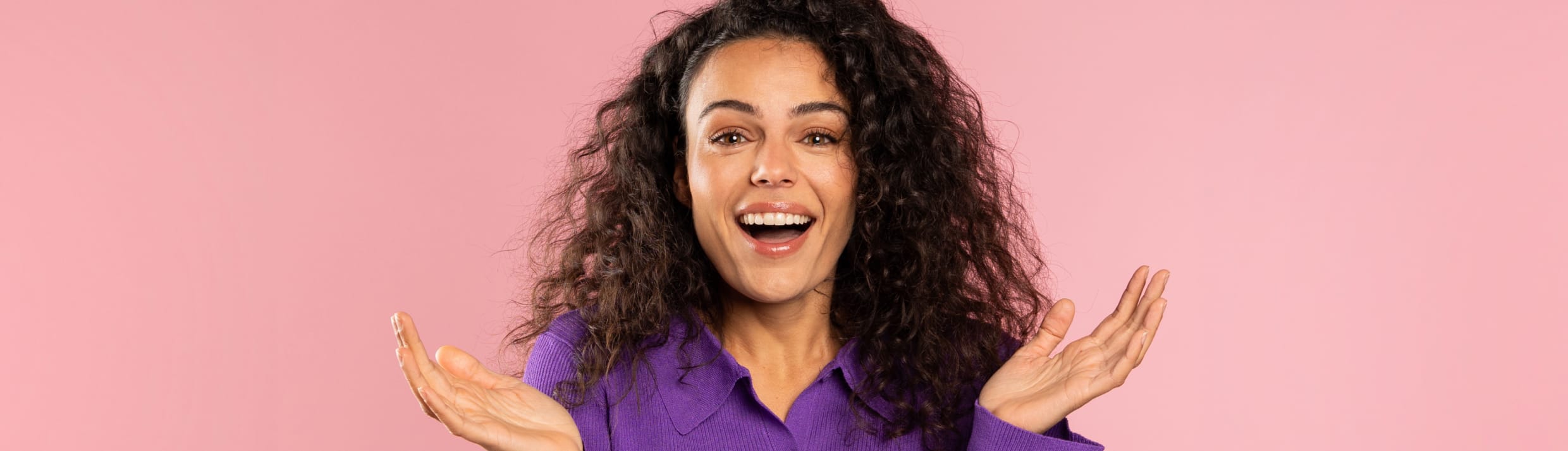 Een vrouw steekt vragend haar handen in de lucht.