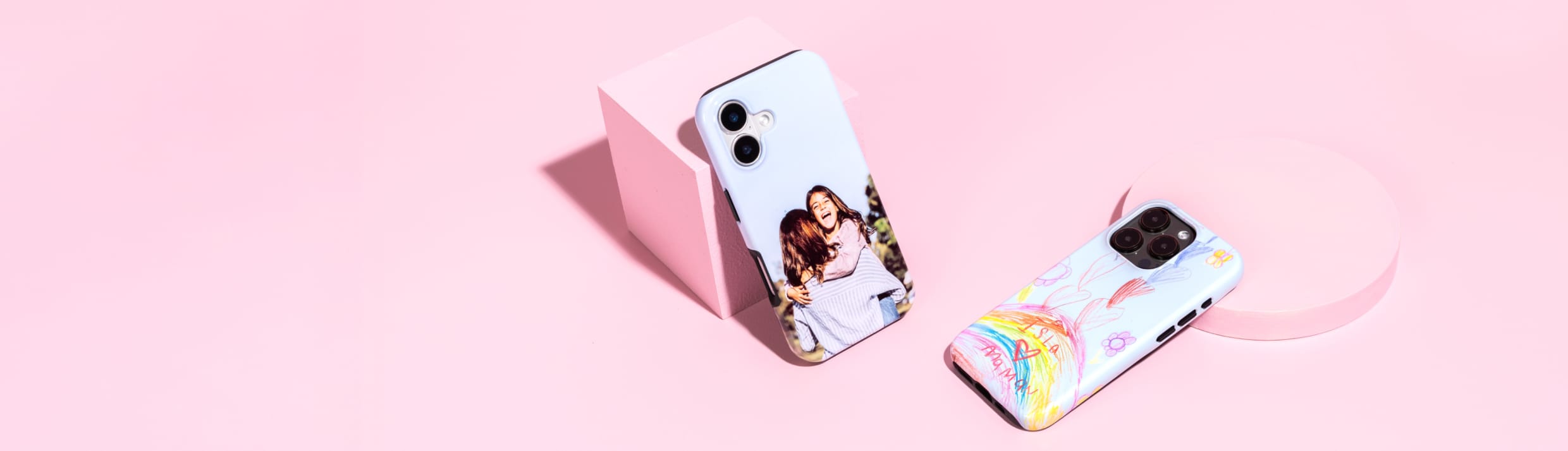 Twee telefoonhoesjes met een eigen ontwerp op een roze achtergrond.