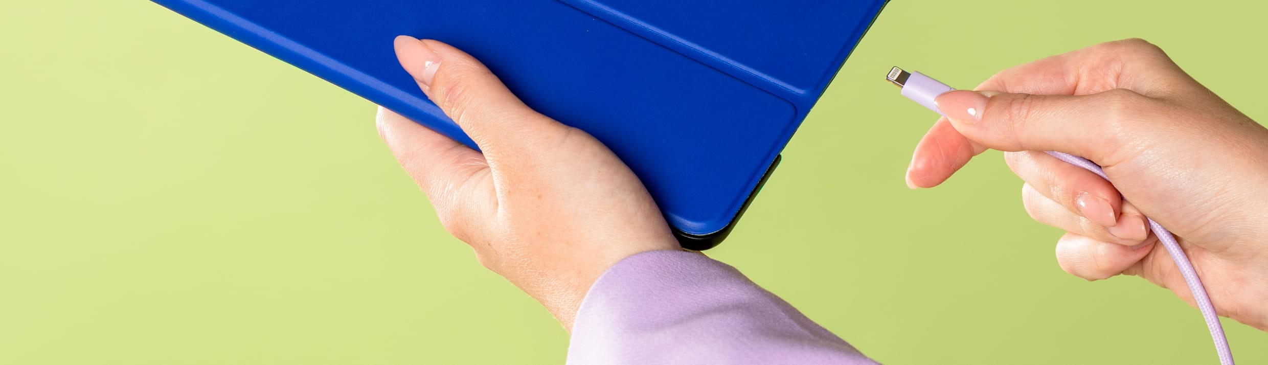 Iemand steekt een oplader in een tablet.