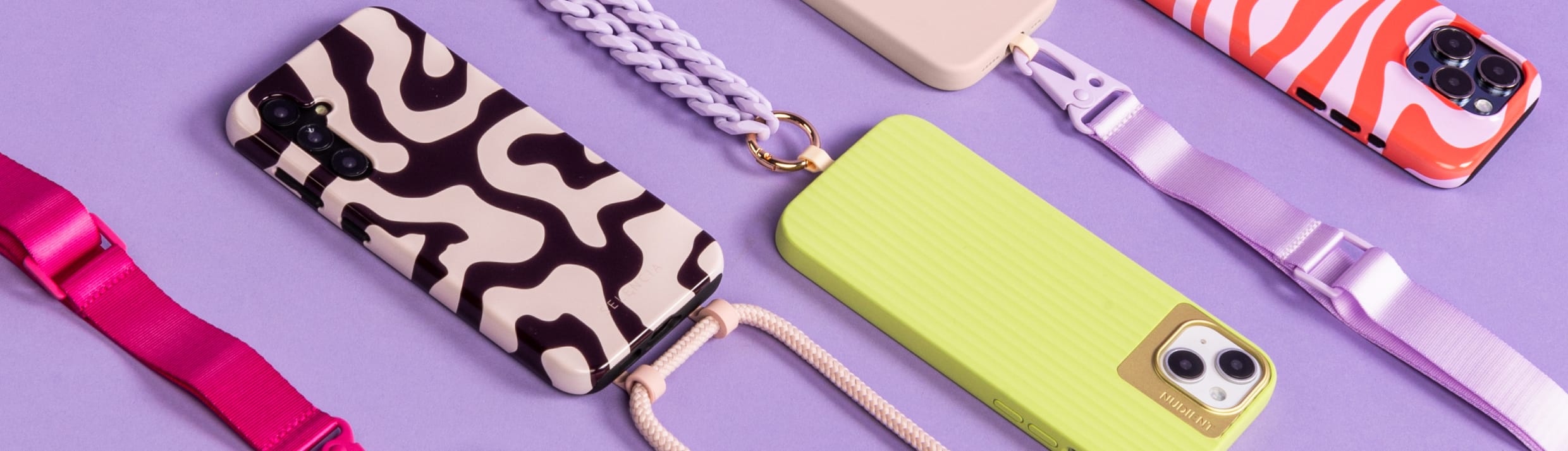 Een flatlay van verschillende kleurrijke telefoonhoesjes met koord.