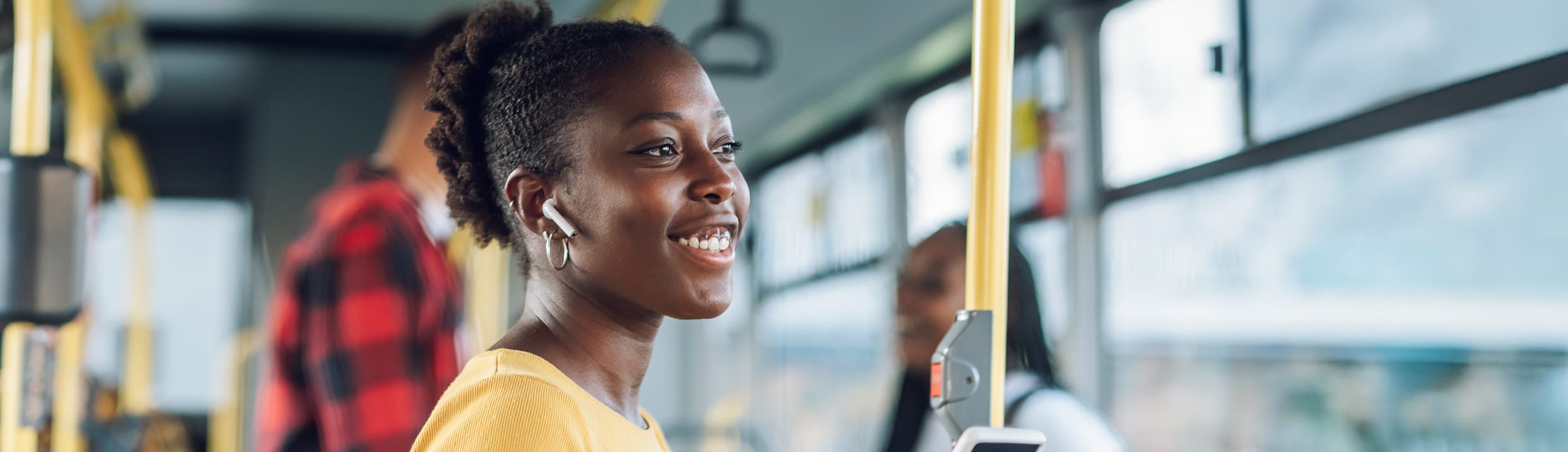 Een vrouw in de bus met draadloze oordopjes.