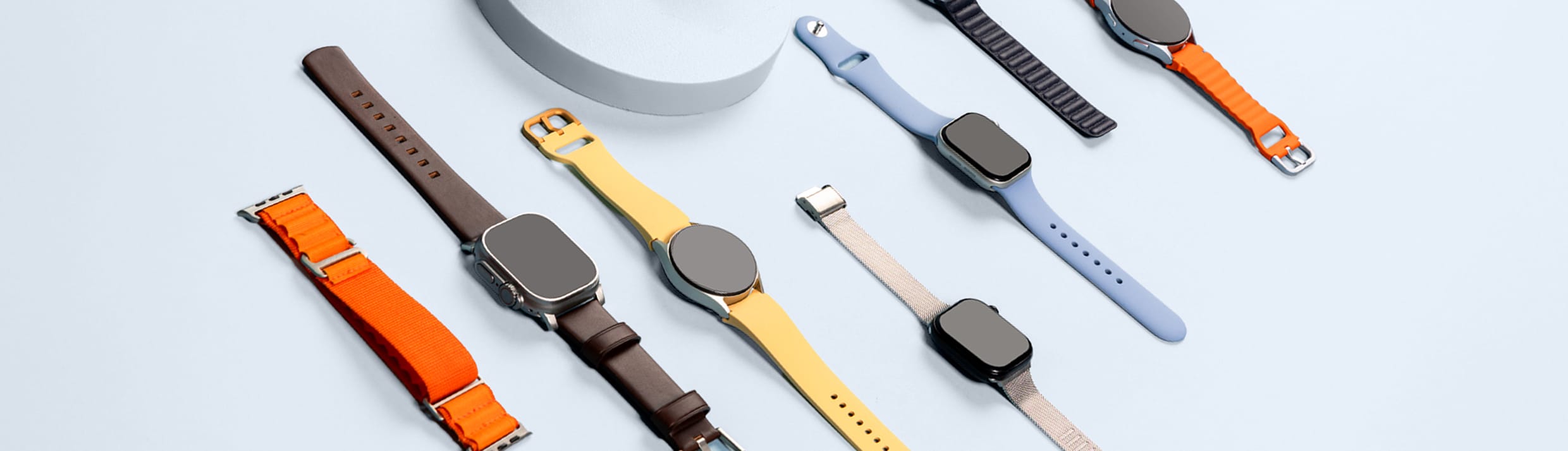 Foto van verschillende smartwatch bandjes op een blauwe achtergrond.