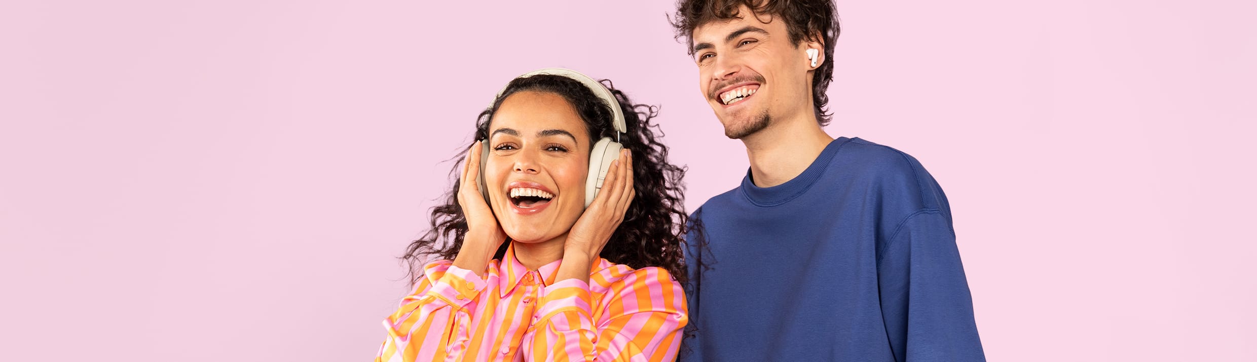 Een man en vrouw luisteren naar muziek met een koptelefoon en oordopjes.