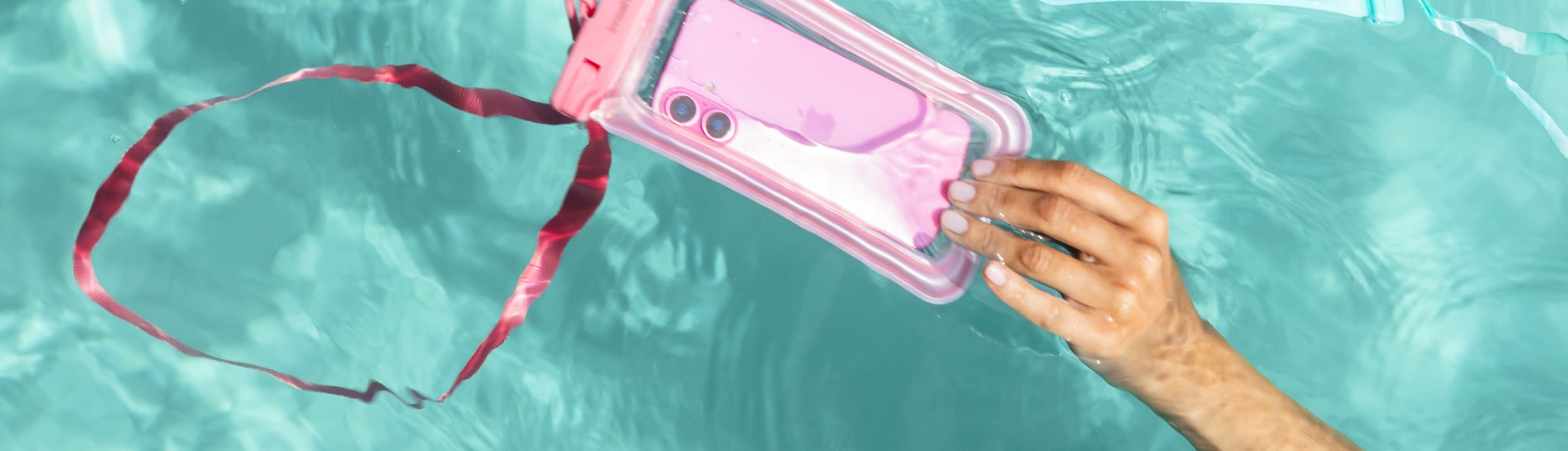Een roze en blauwe imoshion waterdichte telefoonhoes in het water.