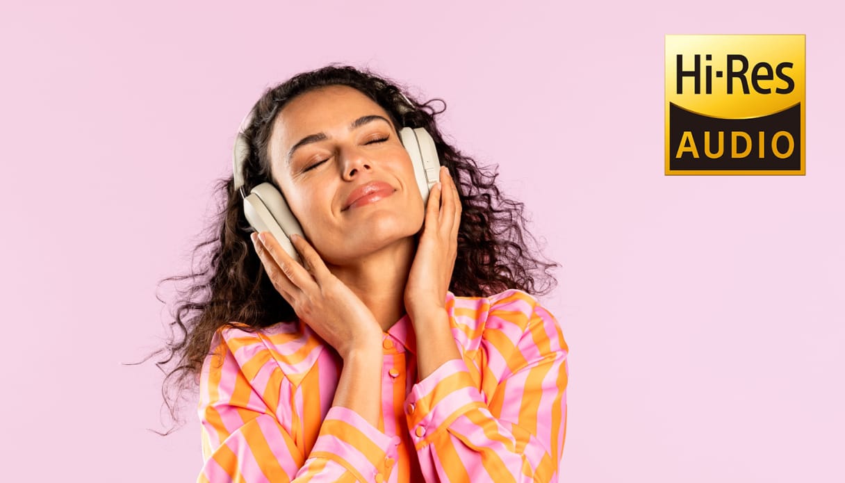Een vrouw luistert naar muziek en het logo van hi-res audio in de hoek.