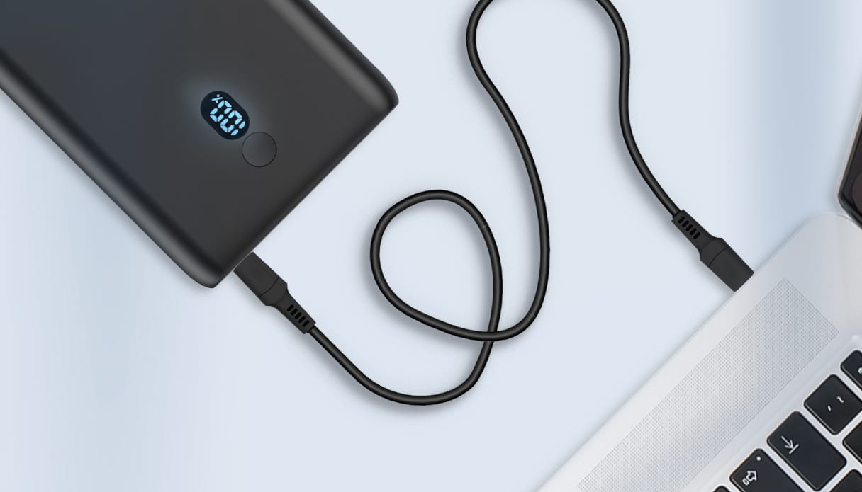 Een imoshion powerbank die aangesloten is op een MacBook.