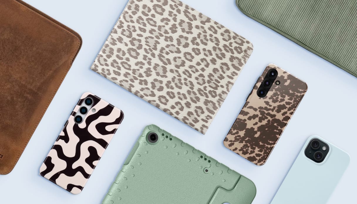 Foto van een tablethoes met panterprint, een groene kidsproof hoes, een leren laptopsleeve en verschillende telefoonhoesjes.