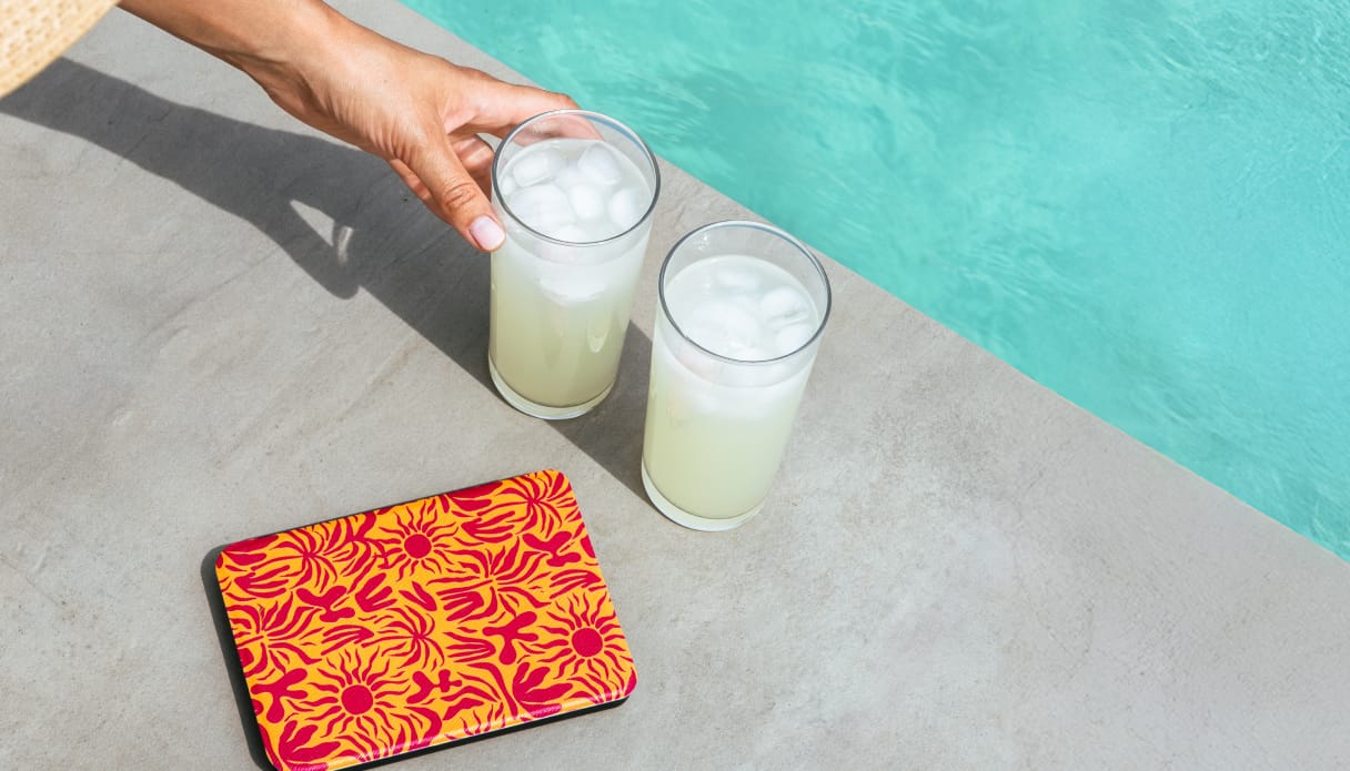 Foto van een e-reader die aan de kant van het zwembad ligt.