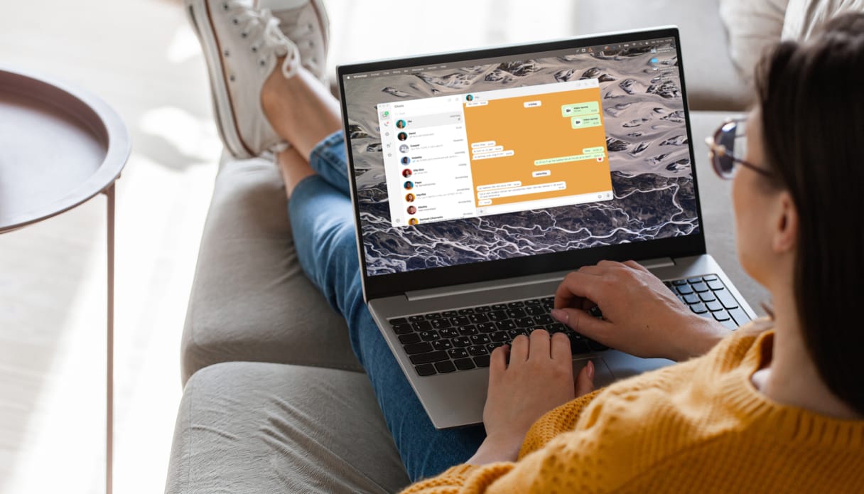 Een vrouw met haar laptop waarbij WhatsApp geopend is
