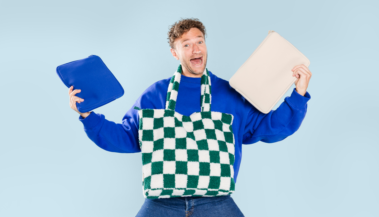 Een man met verschillende laptopsleeves in zijn handen en een laptoptas om zijn nek.