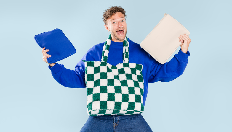Een man met verschillende laptopsleeves in zijn handen en een laptoptas om zijn nek.