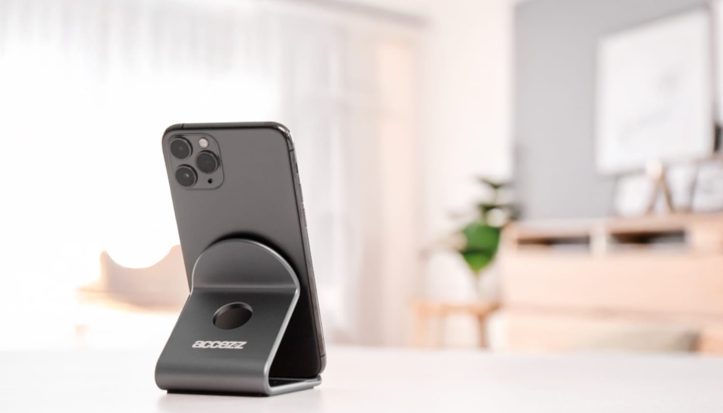 een apple iphone geplaatst in een zwarte telefoonstandaard