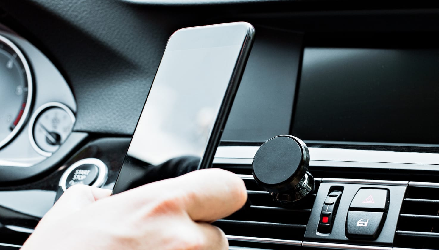 iemand in de auto die telefoon met houders vasthoudt.