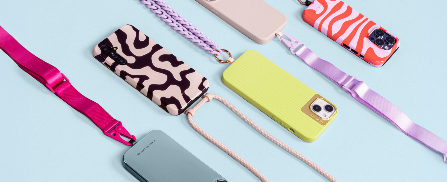 Telefoons met telefoonhoezen en allemaal met telefoonkoord in soorten, maten en kleuren op een lichtblauwe achtergrond.