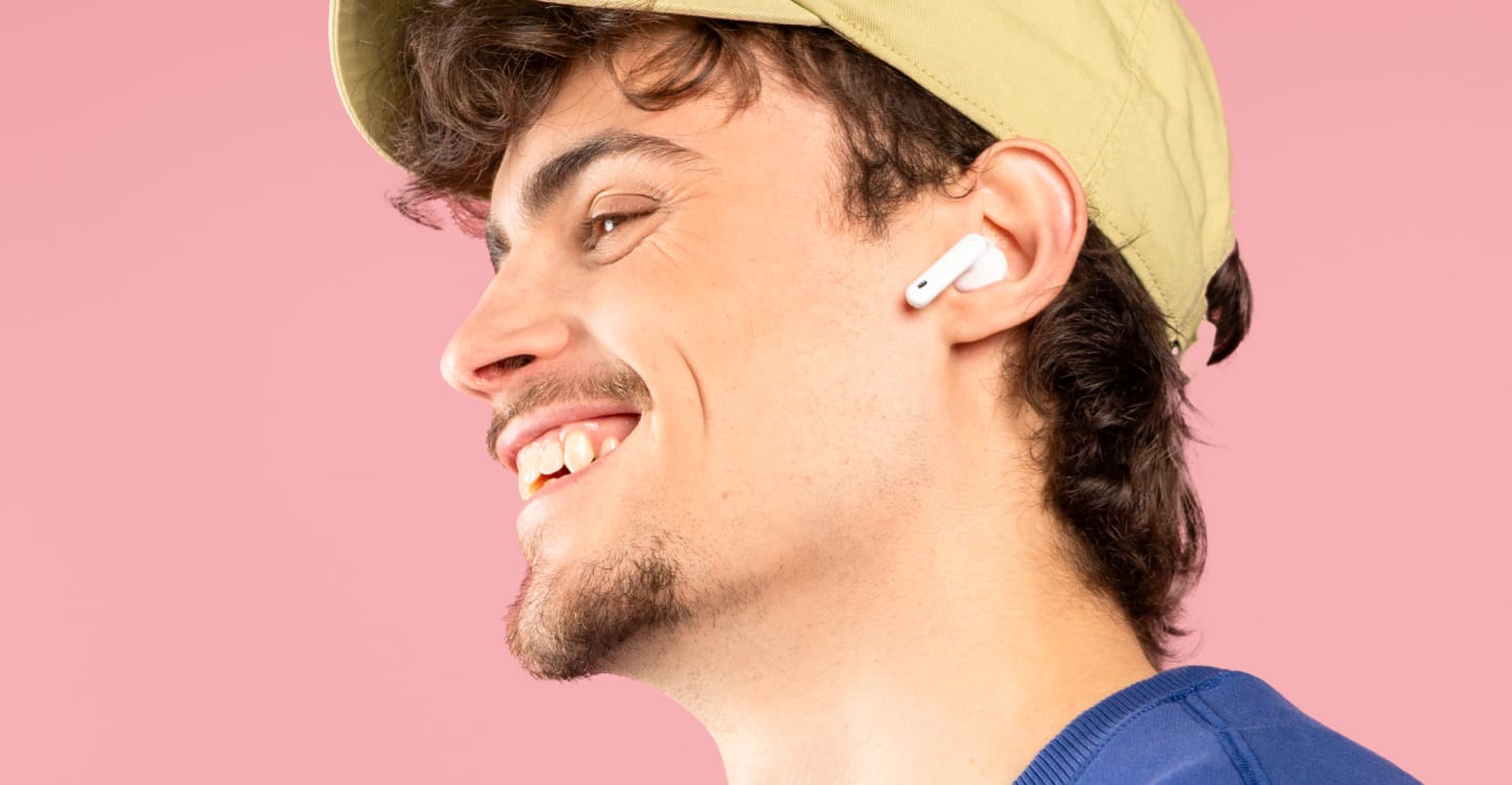 Een man heeft AirPods in zijn oren en luistert muziek.