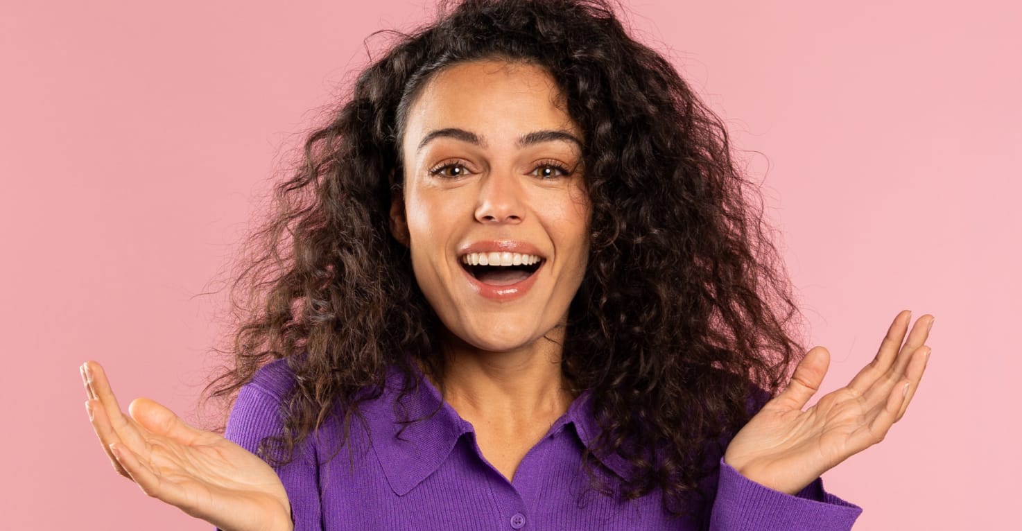 Een vrouw steekt vragend haar handen in de lucht.