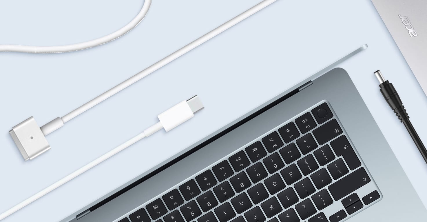 Een Apple MacBook en Acer laptop met verschillende type opladers eromheen.