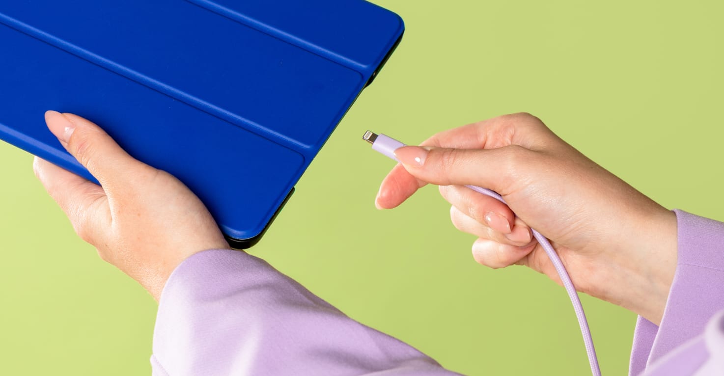 Iemand steekt een oplader in een tablet.