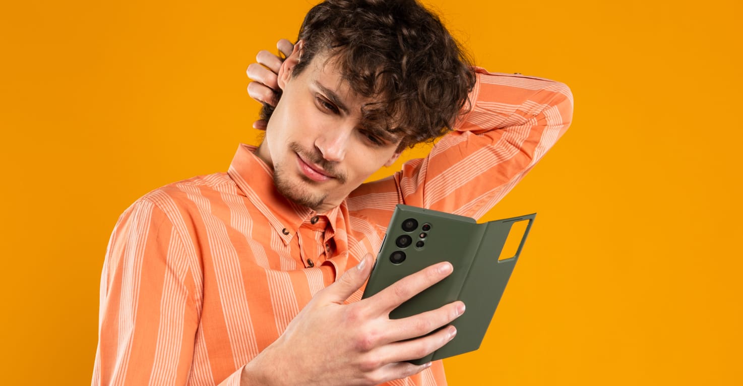 Een man kijkt vragend naar zijn telefoon.