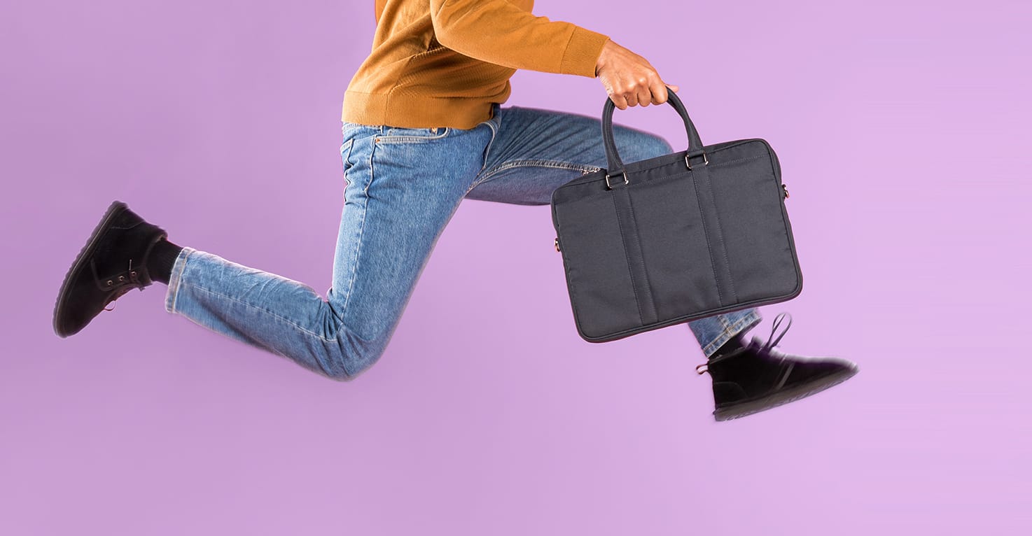 Rennende man met een zwarte laptoptas in zijn hand.
