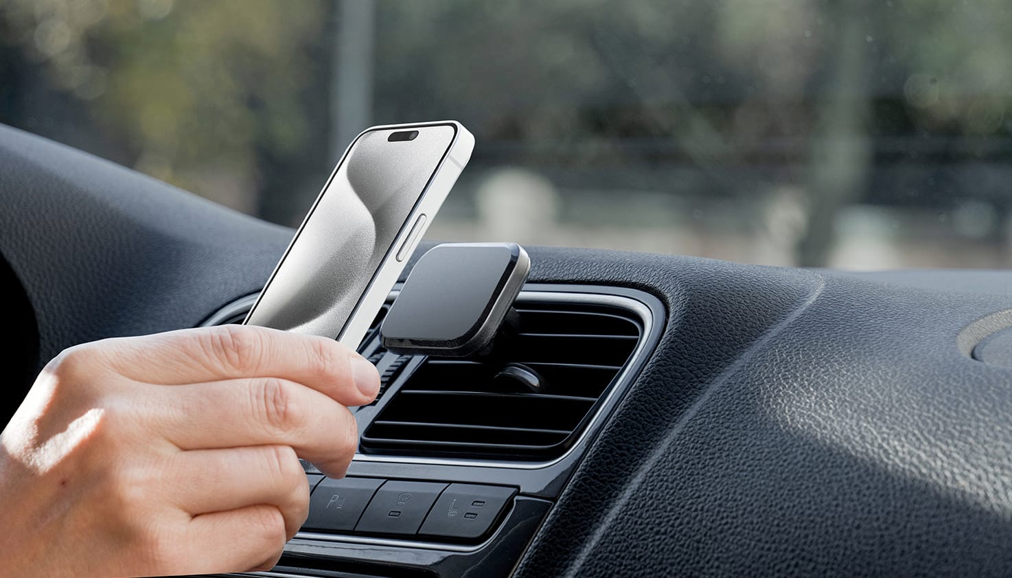 iemand plaats een telefoon op een magsafe telefoonhouder voor de auto