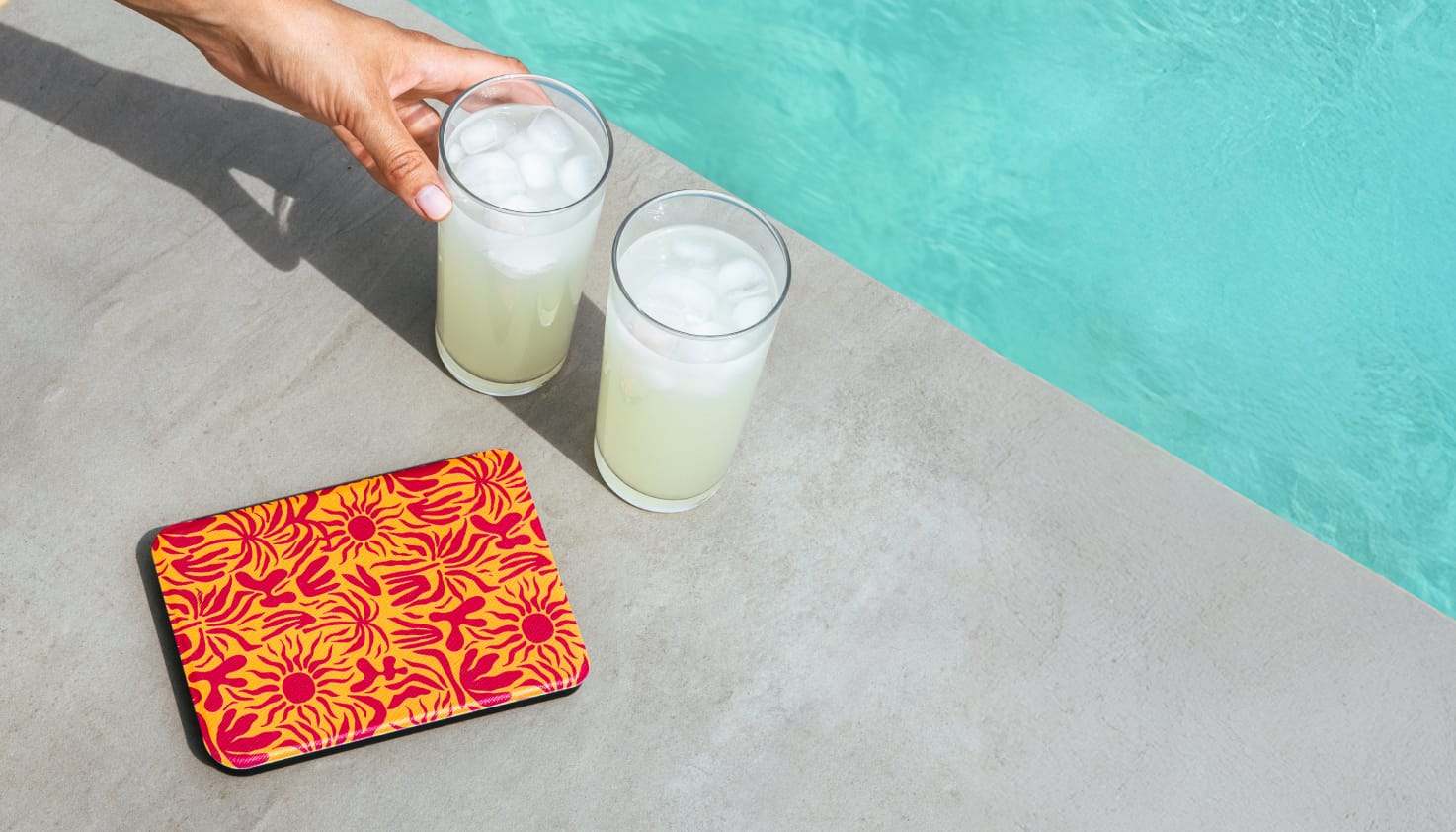 Foto van een e-reader die aan de kant van het zwembad ligt.