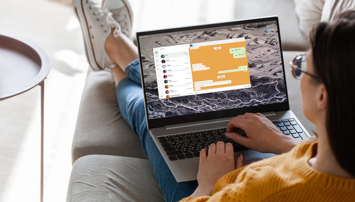 Een vrouw met haar laptop waarbij WhatsApp geopend is