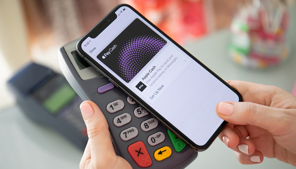 De iPhone wordt op de pinautomaat gelegd om gebruik te maken van Apple Pay.